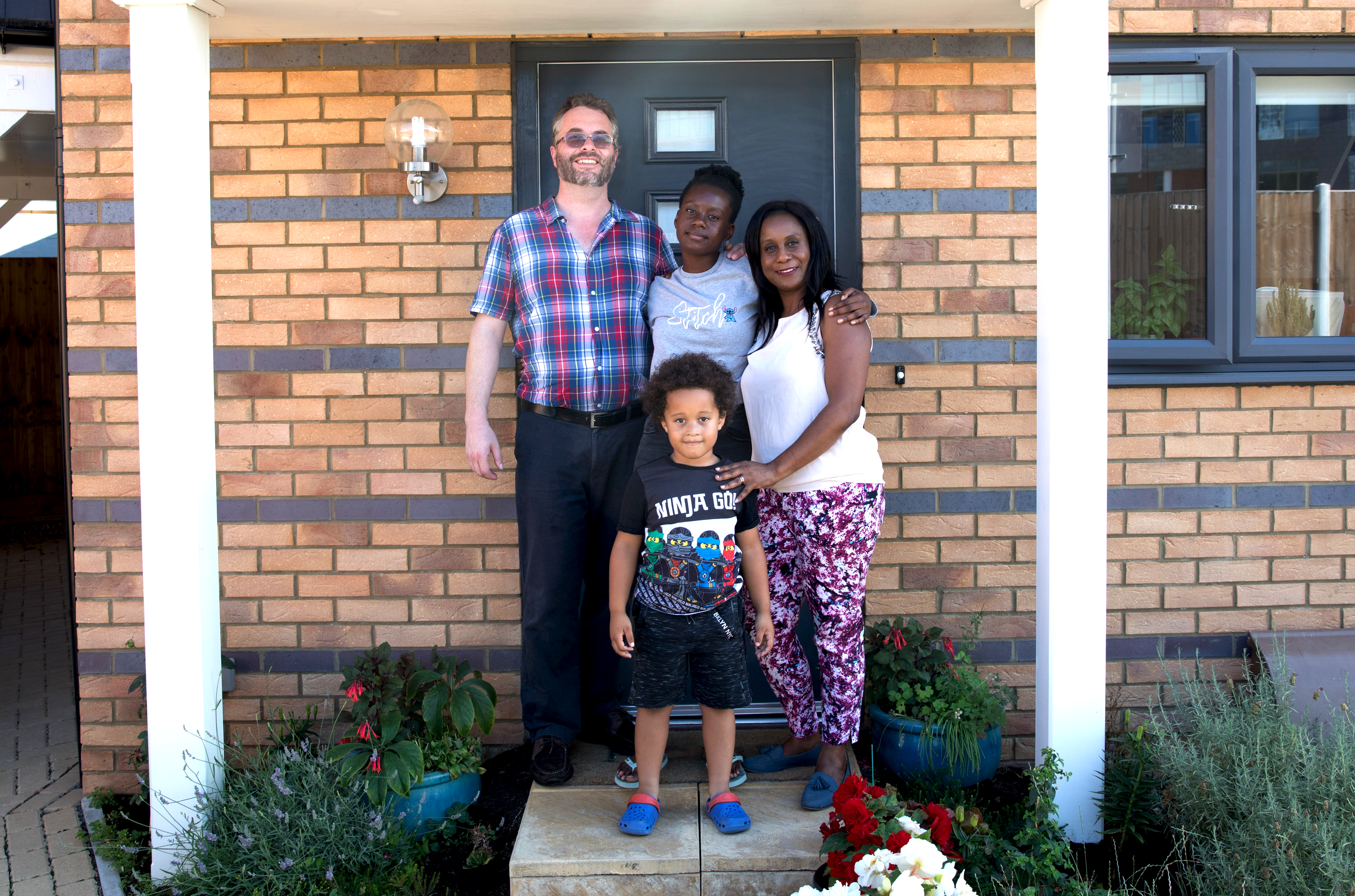 Family Standing In Front Of Their Home1